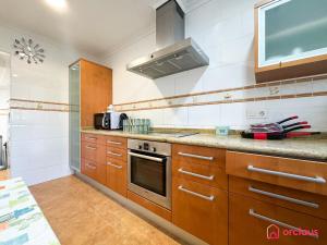 a kitchen with wooden cabinets and a stove at Villa Las Palmas in Benicàssim