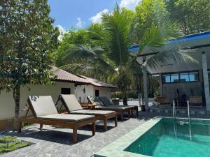 a pool with chaise lounge chairs and a swimming pool at Than Khao Nature Resort and Homestay - Krabi Noi in Krabi