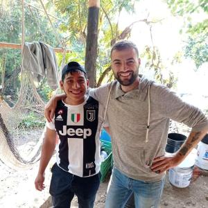 a man is standing next to a young boy at Patziapa in Santiago Atitlán