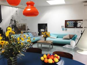 a living room with a blue couch and a table with fruit at La Maison Bleue Trentemoult in Rezé