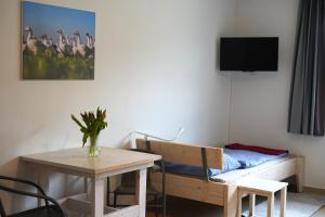 a room with a table and a bed and a table and chairs at Haus Gänsefarm - Ihre Monteurs Wohnung - in Husby