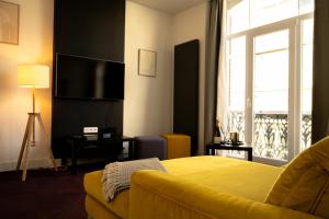 a bedroom with a yellow couch and a large window at Sur un air d'eau in Spa