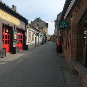an empty street in an old town with red shops at Hidden place in pure center in Novi Sad