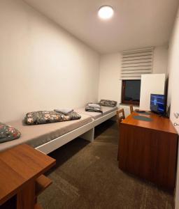 a room with two beds and a desk and a computer at JustInRent Next by Gallery Szpitalna 4D-2 in Legnica