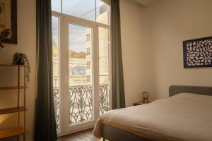 a bedroom with a bed and a large window at Sur un air d'eau in Spa +10 photos