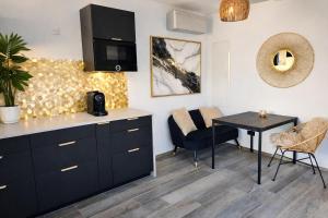 a kitchen with a counter and a table and chairs at Suite neuve piscine privée Les Charmettes in La Ciotat