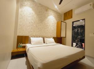 a bedroom with a large bed in a room at Rukkmannie Holiday Inn in Ujjain