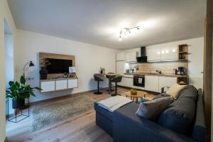 a living room with a couch and a kitchen at Ferienwohnung TaJoLe in Heinade