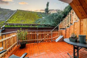 a patio with a wooden fence and a table at Ferienwohnung TaJoLe in Heinade