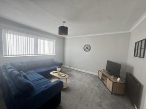 a living room with a blue couch and a tv at Grieve Apartment in Jedburgh +8 photos