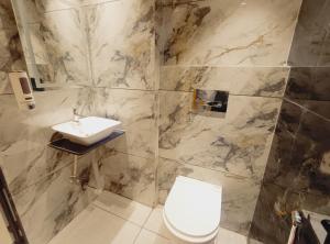 a bathroom with a toilet and a sink at Rukkmannie Holiday Inn in Ujjain