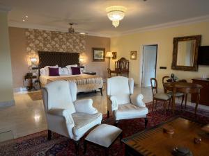 a bedroom with a bed and two chairs and a table at Los Cinco Enebros Hotel & Spa by Bossh! Hotels in Robledo de Chavela