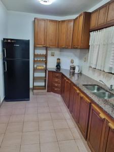 a kitchen with a black refrigerator and wooden cabinets at Casa a metros de todo in Federación