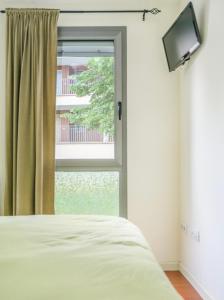 a bedroom with a bed and a window with a television at Terraza Varellas in Latas +13 photos
