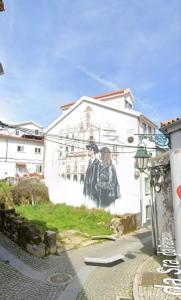 a mural of two men on the side of a building at Refúgio da Estrela Covilhã in Covilhã