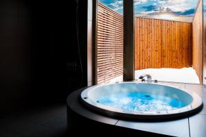 a bath tub in a bathroom with a window at ヴィラブラマーレ in Kitahiroshima +37 photos