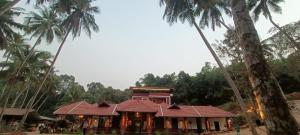 a house with palm trees in front of it at Srikadhama in Udupi +29 photos