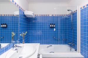 a blue tiled bathroom with a tub and a sink at Parador de Fuente Dé in Fuente Dé +33 photos