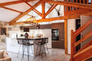 a kitchen with a large island with bar stools at Résidence Espéraza ADULTS ONLY in Espéraza