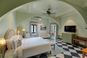a bedroom with a bed and a living room at lebua Udaipur Daulatgarh in Udaipur
