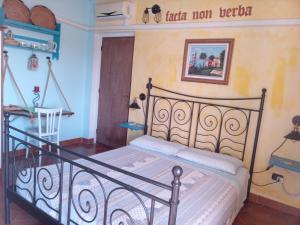 a bedroom with a bed with a wrought iron headboard at Locanda D'Ogliastra in Triei