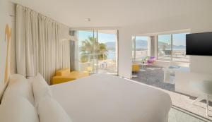 a bedroom with a white bed and a view of the ocean at nhow Marseille in Marseille