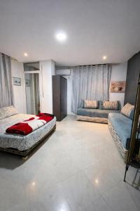 a bedroom with two beds and a couch in it at Coin de repôs in Oujda