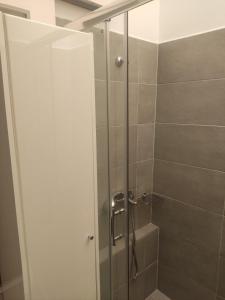 a shower with a glass door in a bathroom at Angel House in Ermoupoli