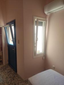 a room with a bed and a window and a door at Angel House in Ermoupoli