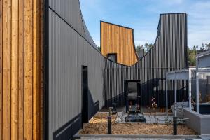 a building with a black and wooden facade at Three Peaks Thermal Villas in Banya