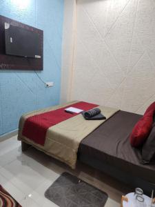 a bedroom with a bed with a tv on the wall at SRT Homes Ranchi in Rānchī