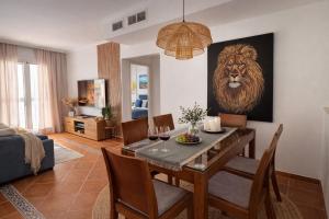a dining room with a table and a lion painting on the wall at Casa de Andres Mojácar in Mojácar