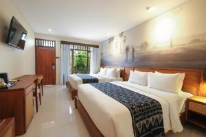 a hotel room with two beds and a desk at Matahari Bungalow in Legian +65 photos