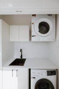 a kitchen with a washing machine and a sink at The Hideaway on McFarlane, Mudgee in Mudgee +20 photos