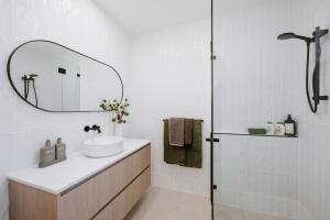a bathroom with a sink and a shower with a mirror at The Hideaway on McFarlane, Mudgee in Mudgee