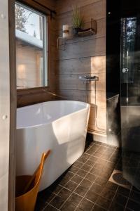 a white bath tub in a bathroom with a window at WALD Villas - Aavasaksa, Lapland in Aavasaksa