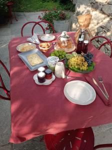 a red table with plates of food on a red table cloth at Una casa tra gli alberi in Tresivio +32 photos
