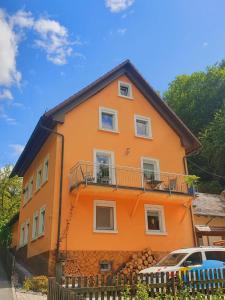 an orange house with a balcony on the side of it at Haus am Thiesenring in Bad Berneck im Fichtelgebirge +2 photos