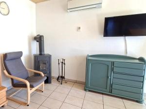 a living room with a tv and a chair and a stove at Haus 26 Natur Ferienpark - Ruhe, Natur und Komfort für erholsame Tage fern vom Alltag in Nieheim