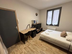 a bedroom with a bed and a desk and a window at Sur Tulle - Le Refuge - 1 Piece in Tulle +2 photos