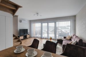 a living room with a couch and a table with chairs at LakeHome&Spa nad Jeziorem Czorsztyńskim in Kluszkowce
