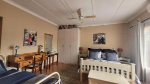 a bedroom with two beds and a desk and a table at AtHome Apartments in Mokopane +62 photos