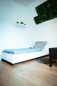 a white bed in a room with plants on the wall at Wohnung am See in Wetter