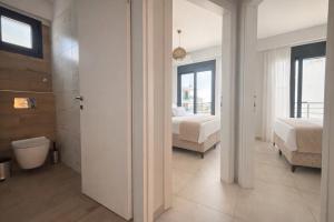 a bathroom with two beds and a toilet in a room at Ariadne Stay Complex by Horizon Homes in Ofrínion