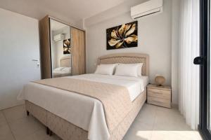 a bedroom with a large white bed and a mirror at Ariadne Stay Complex by Horizon Homes in Ofrínion