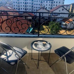 a table and chairs on a balcony with a view of a city at Apartman River in Bijeljina