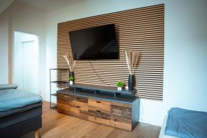 a living room with a large flat screen tv on a wall at Wohnung am See in Wetter