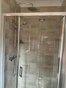 a shower with a glass door in a bathroom at Carrick Chalets in Cairndow