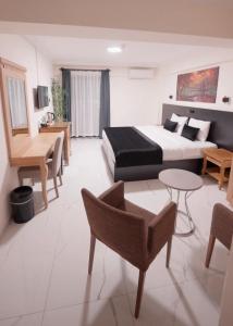 a hotel room with a bed and a table and chairs at La Vista in Gaziemir
