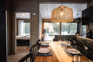 a dining room with a wooden table and chairs at WALD Villas - Aavasaksa, Lapland in Aavasaksa